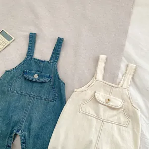 Détail de la salopette bébé avec grandes poches de poitrine et coutures contrastées