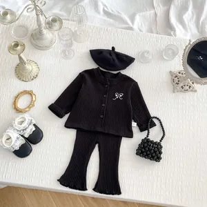 Detail of baby girl black ribbed cardigan and flared pants set with bow embroidery