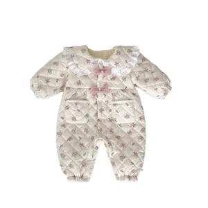 Floral quilted baby romper with lace collar and pink bows on white background