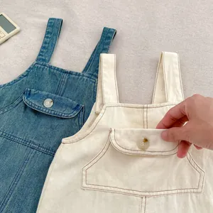 Détails de salopettes en jean pour bébé avec coutures contrastées et boutons marbrés