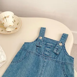 Détail de la robe en jean bleue pour filles avec boutons blancs et poches pratiques