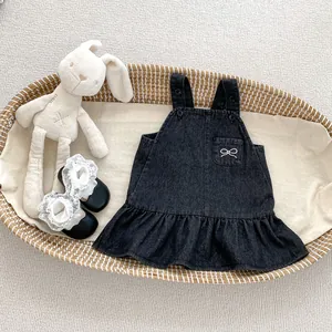 Detail eines Baby-Jeanskleides für Mädchen mit weißem Schleifen-Stick und Volant-Saum
