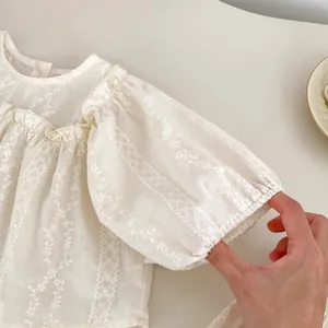Détail de broderie florale sur manche bouffante en coton respirant pour filles