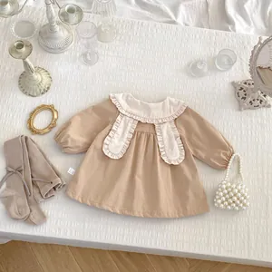 Close-up of baby girl brown dress with large white ruffle collar and knit textures