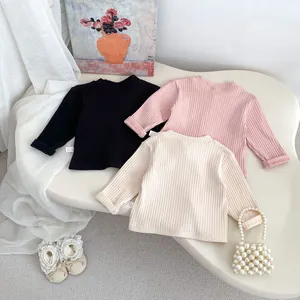 Detailed flat lay of ribbed cotton long sleeve baby tops in black, pink and beige