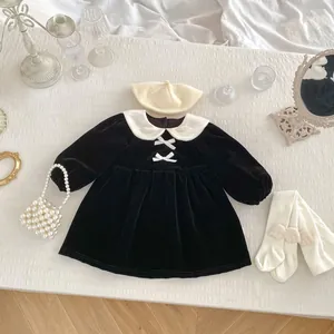 Detailed flat lay of velvet princess dress with Peter Pan collar and bow details