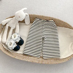 Détail du pantalon rayé en maille avec taille élastique et chaussons en dentelle