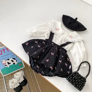 Ensemble fille avec chemise blanche à manches longues et jupe à bretelles à pois noirs
