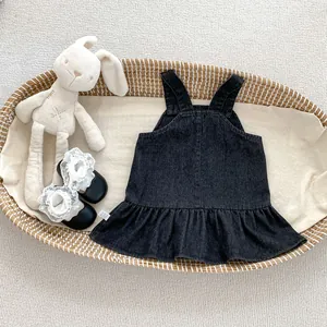 Detail von Mädchen Denim Trägerkleid mit Rüschen und Mary Jane Schuhen im Korb