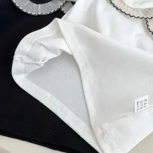 Detailansicht des Rüschenkragens und des Waschetiketts an der Babybekleidung