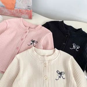 Detailed view of ribbed knit cardigans with bow embroidery and pearl accents