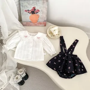 Ensemble printemps bébé fille avec chemise à volants et salopette marine à motifs nœuds