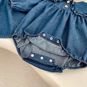 Détail de barboteuse en jean pour bébé avec col volanté, boutons en bois et boutons-pression