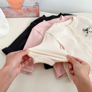 Three colors of ribbed baby cardigans showing high elastic knit fabric and bow detail