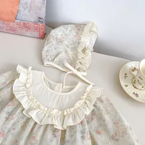 Dettaglio tutina neonata floreale vintage con colletto a balze e cappello coordinato