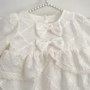 Elegant white infant bodysuit with floral lace embroidery and bow details for girls