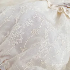 White cotton baby bodysuit with delicate flower embroidery and vine lace details