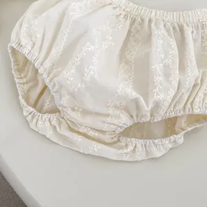 Détail du short bouffant en coton crème avec broderies de fleurs blanches délicates