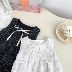 Detailansicht von Tweed-Kleinkinderkleidern mit eleganten Schleifen und Textur