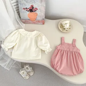 Detail of baby girl clothing set featuring white lace collar shirt and pink romper