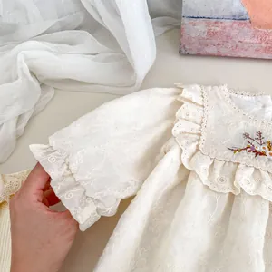 Detail of baby girl floral embroidery bodysuit with delicate lace ruffles and soft texture