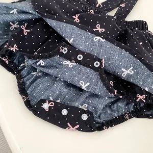 Body bébé noir à pois avec nœuds roses et boutons-pression à l'entrejambe
