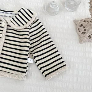 Détail du cardigan rayé pour bébé avec col en dentelle et tissu en coton texturé doux