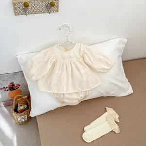 Détails de l'ensemble bébé en coton crème avec broderie florale et dentelle