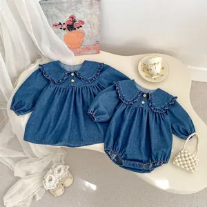 Détails d'une robe et d'un body en jean pour bébé avec col à volants et boutons en bois
