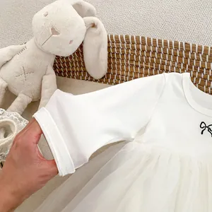 Detail der gerippten Bündchen und weißem Tüll am langärmeligen Baby-Mädchen-Kleid