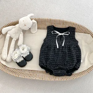 Details von Tweed Baby Body mit Schleife und Spitzenschuhen im Weidenkorb