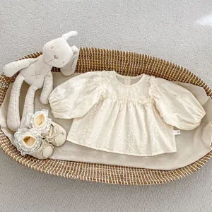 Détails de broderie florale et dentelle sur chemise pour bébé avec col à volants doux
