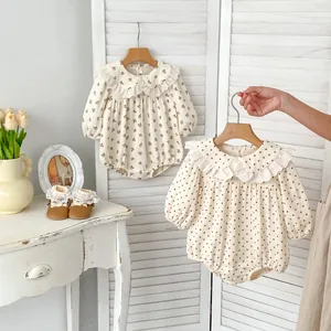 Close-up of baby floral romper featuring a delicate white lace ruffled collar and long sleeves