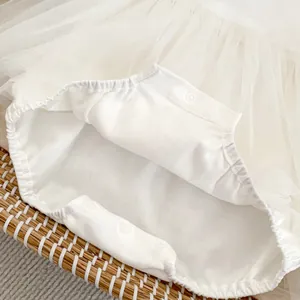 Detail der Baby-Body mit weißem Tüllrock und praktischem Dreiknopf-Druckverschluss