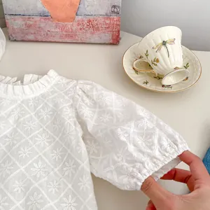 Détail du haut en dentelle blanche pour filles avec broderie florale et col à volants