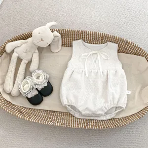Details von Baby-Strampler im Tweed-Stil mit Schleife und Schuhen in einem Korb