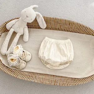 Détail du short bouffant en coton crème pour bébé avec dentelle et chaussures à ruban