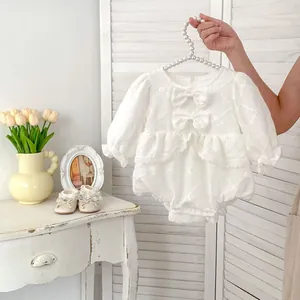 Detail of white floral jacquard baby romper with lace ruffles and matching shoes