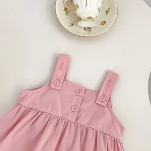 Detail of pink cotton baby suspender top with three buttons and soft pleated texture