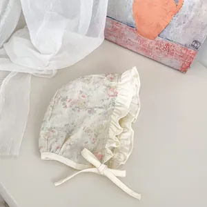 Dettaglio del cappello da sole per neonati a fiori con volant e lacci di fissaggio