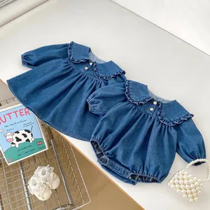 Détail de la barboteuse et robe en jean pour bébé avec col volanté et boutons