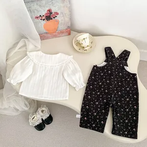 Detalle de conjunto para bebé con peto floral, camisa con volantes y bolsillos bordados