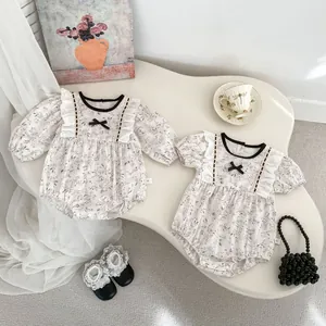 Floral baby bodysuit with ruffles and bow details in a cozy home setting