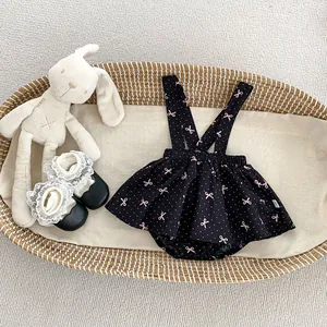 Barboteuse à bretelles noire pour bébé avec nœuds roses et chaussures de marche en dentelle