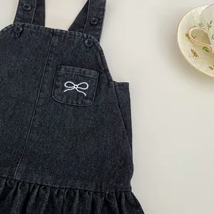 Detailansicht eines Jeanskleides für Mädchen mit Schleifenstickerei und Rüschensaum