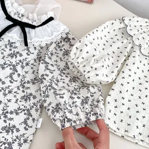 Détails de chemises bébé à fleurs avec col en dentelle et nœud en velours noir