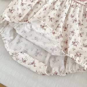 Detailed view of baby floral romper snap button closure and elastic leg openings