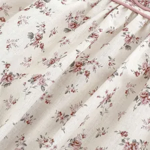 Close-up of floral cotton romper fabric with pink patterns and delicate ruffled edges