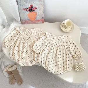 Detail of floral and polka dot baby bodysuits with lace collars and matching socks