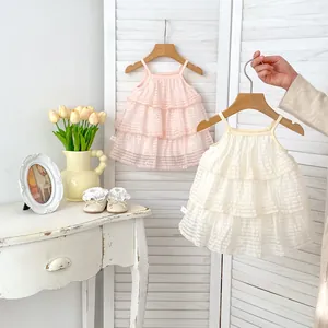Detail eines gestuften Tüll-Kuchenkleides für Mädchen mit feiner Schleifenstickerei und Spitzenschuhen